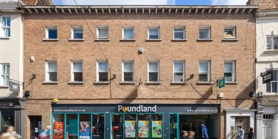 70 Low Petergate, York, photographed square on from the street. A three storey brick building with sash windows to the two upper floors in medical use, the Poundland shopfront running the width of the ground floor, and the separate entrance door to number 70 at the right hand end.