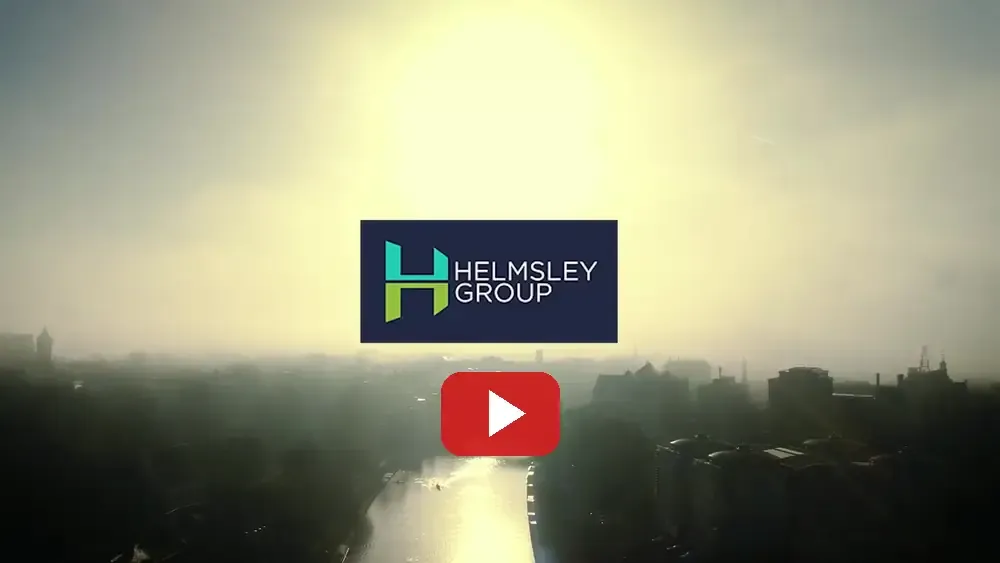 The opening frame of the Helmsley Group film, showing the company logo over an aerial view of York and the River Ouse at dawn, with a red play button below it.